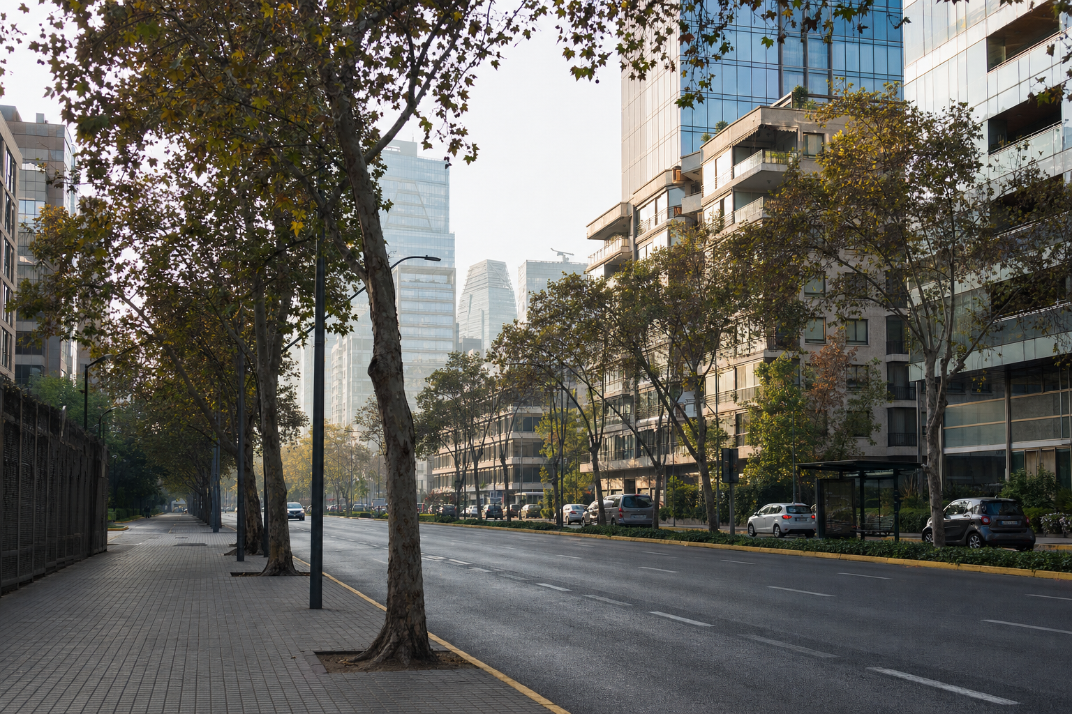 Avenida arbolada en El Golf, Las Condes, con torres de oficinas y edificios residenciales