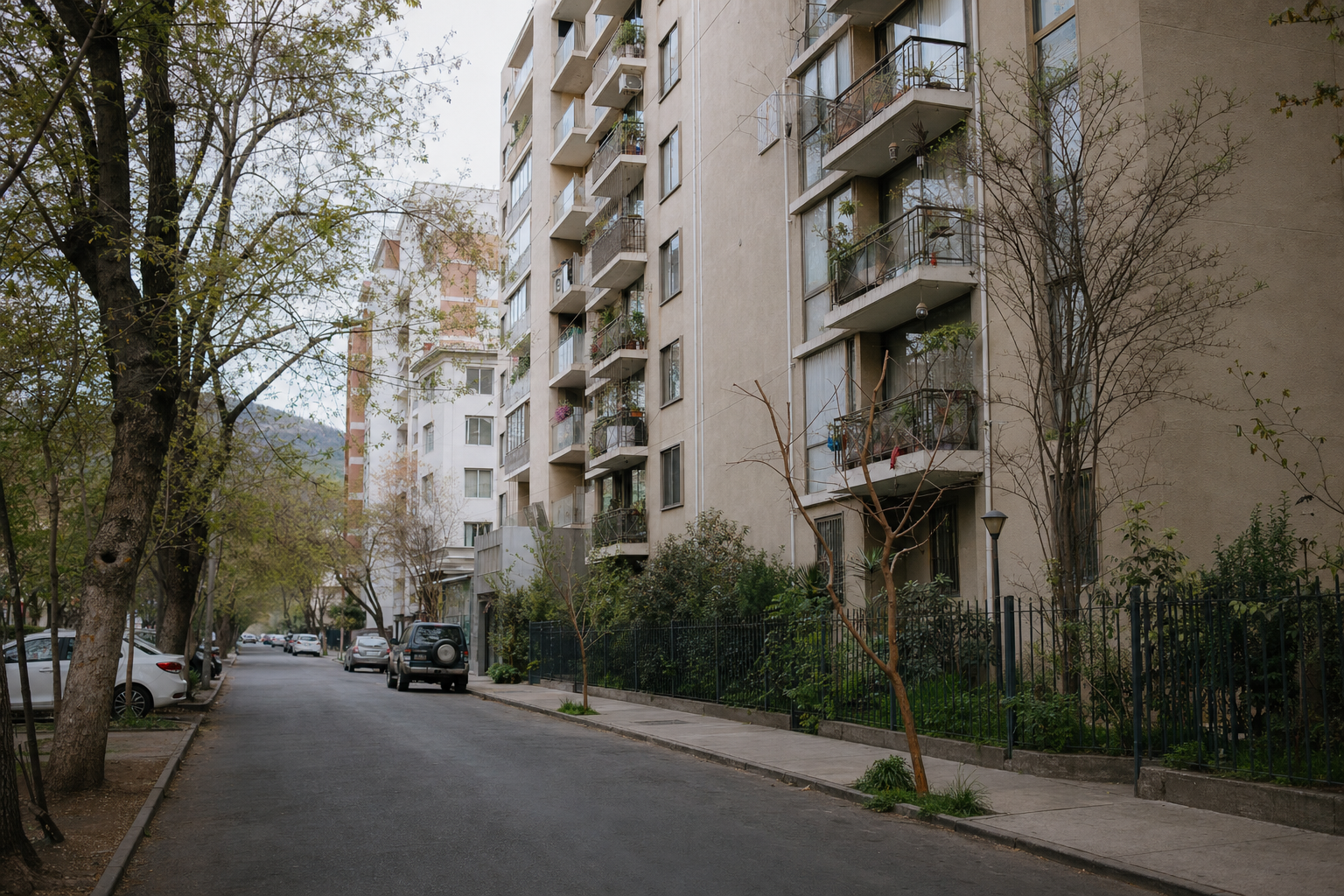 Calle residencial arbolada con edificios de departamentos en Santiago
