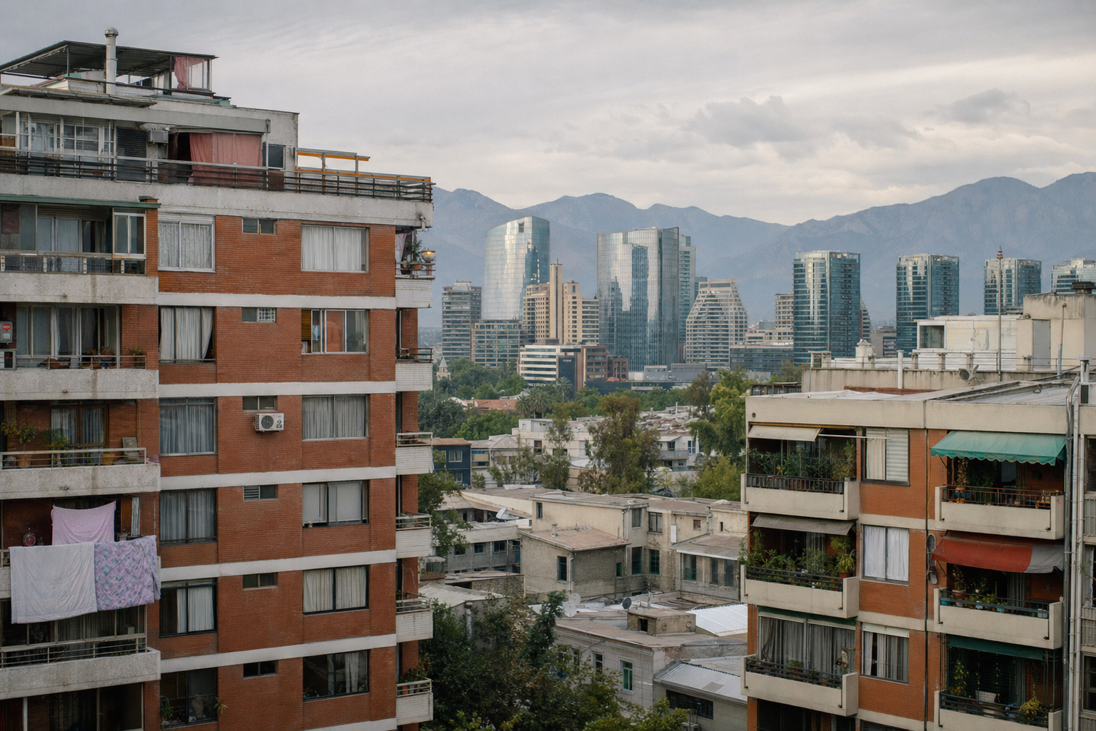Edificios residenciales en Santiago con torres del sector oriente y la cordillera de los Andes al fondo